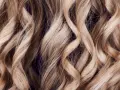 Falujące, blond włosy z subtelnymi refleksami, jak po artystycznym flamboyage.