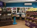 Wnętrze sklepu z kosmetykami kontigo. Rzędy kolorowych paletek cieni do powiek i szminek na półkach.