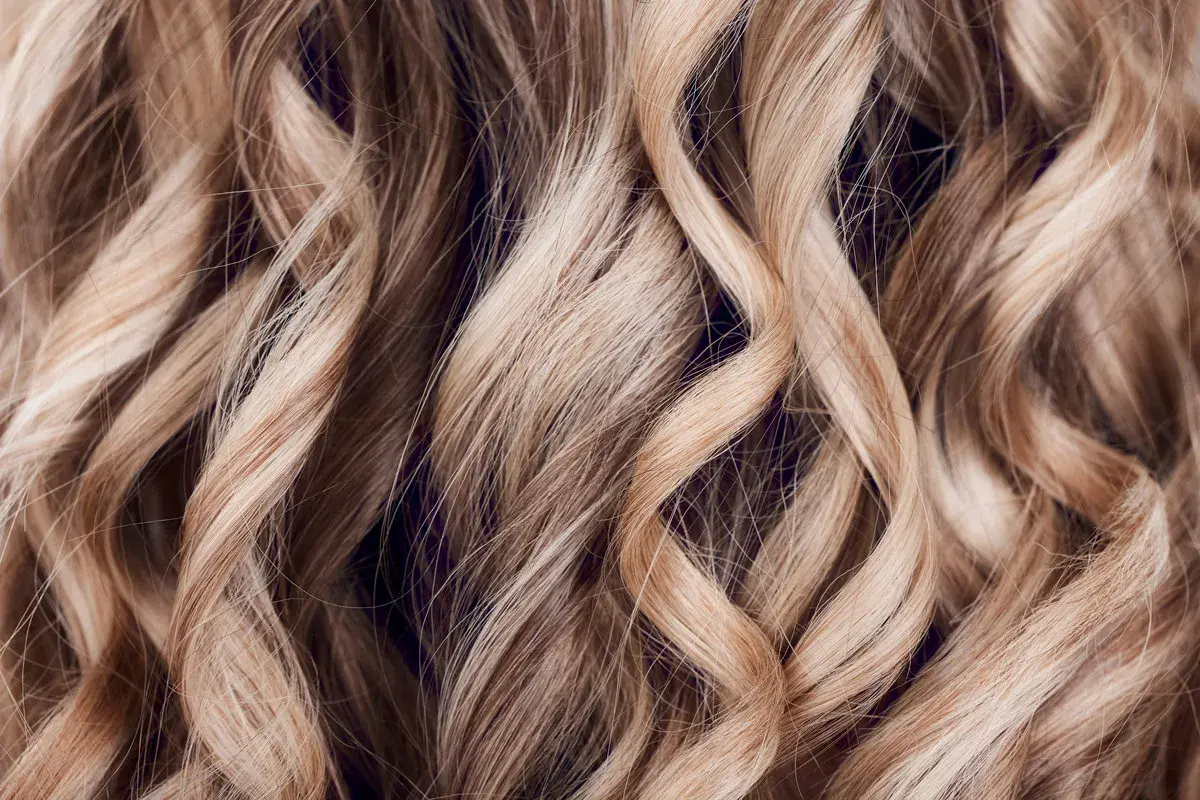 Falujące, blond włosy z subtelnymi refleksami, jak po artystycznym flamboyage.
