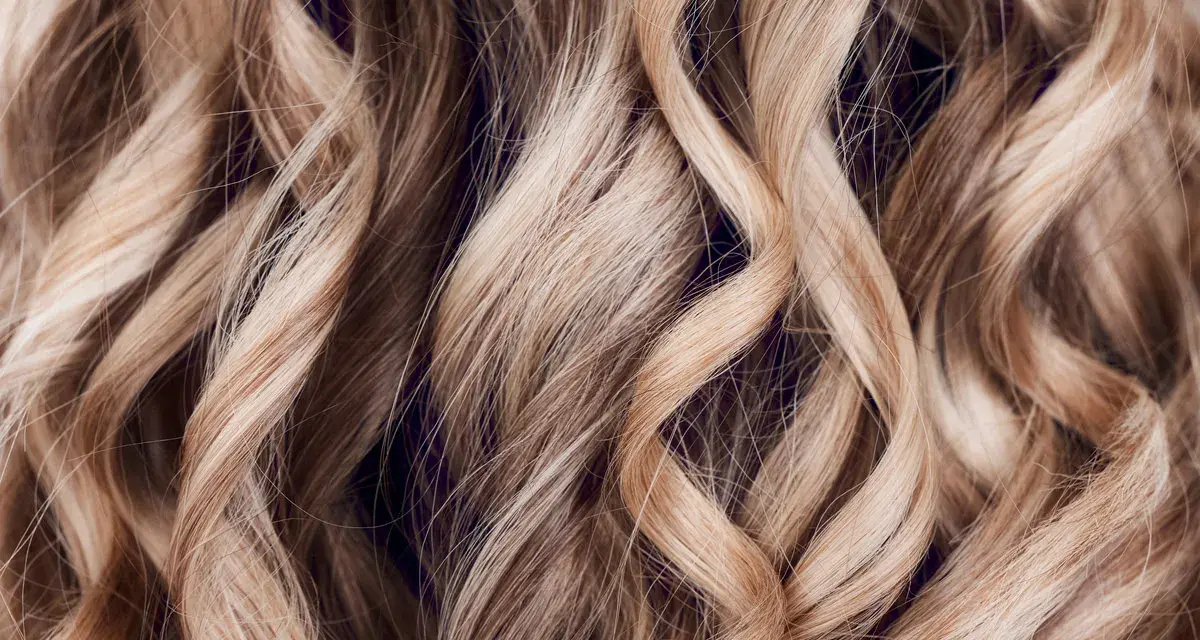 Falujące, blond włosy z subtelnymi refleksami, jak po artystycznym flamboyage.