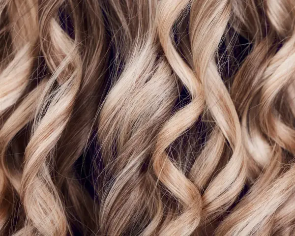 Falujące, blond włosy z subtelnymi refleksami, jak po artystycznym flamboyage.