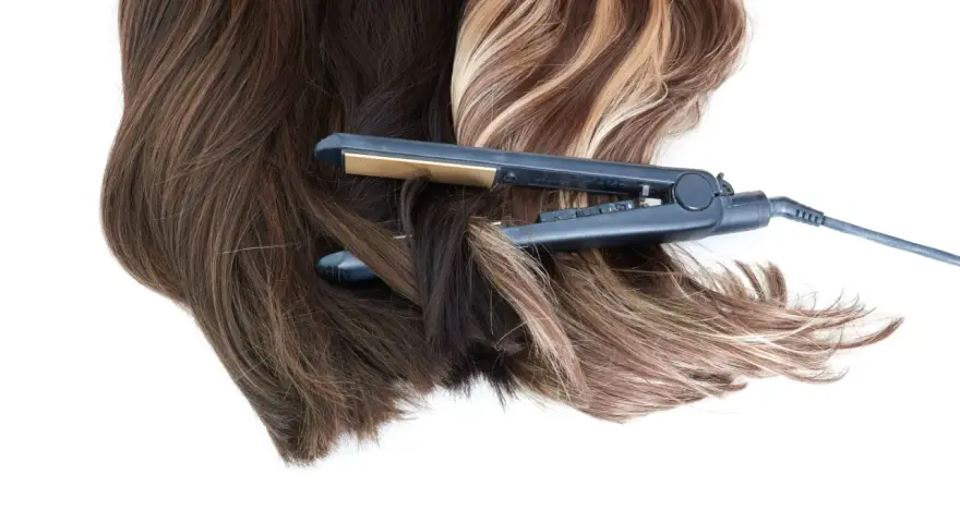 Prostownica do włosów w trakcie tworzenia fal. Dowiedz się, jak zrobić fale prostownicą na ciemnych i jasnych pasmach.