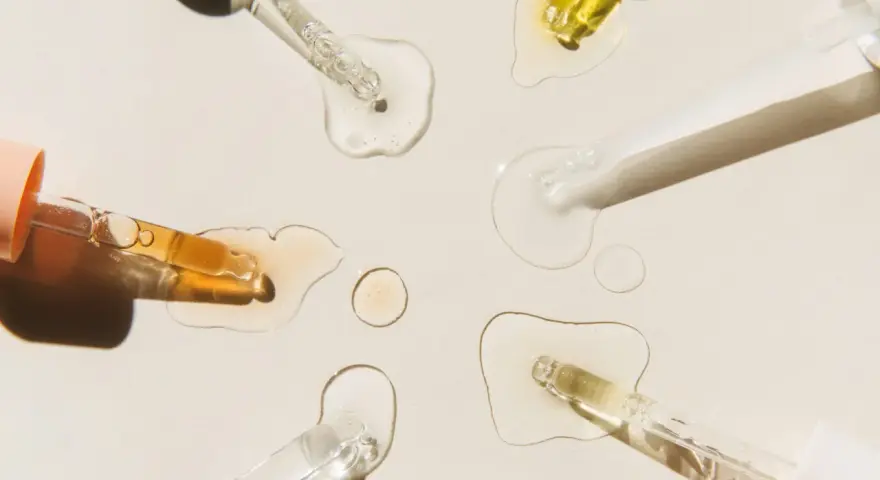 Krople serum i pipetki na jasnym tle.
