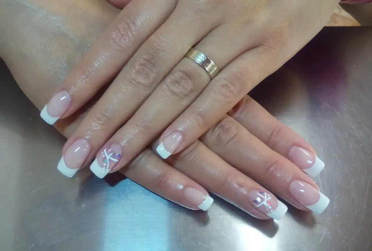 Eleganckie paznokcie żelowe krok po kroku: french manicure z delikatnym zdobieniem.