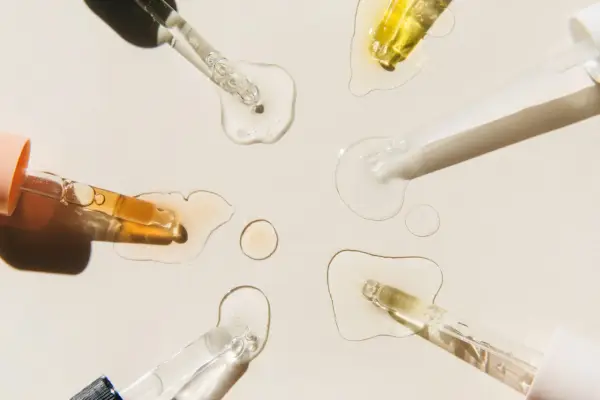 Krople serum i pipetki na jasnym tle.